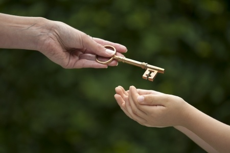 adult handing a key to a child